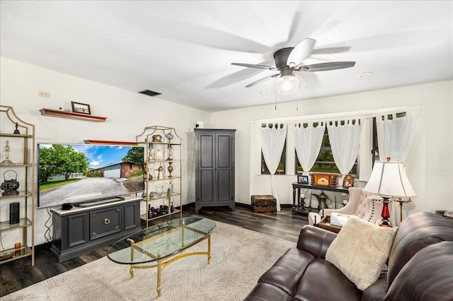 living room with dark hardwood / wood-style floors, ceiling fan, and a textured ceiling