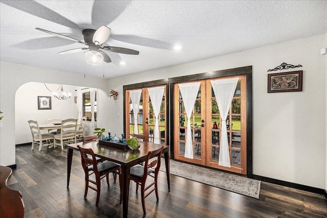 dining room featuring a textured ceiling, french doors, ceiling fan with notable chandelier, and dark hardwood / wood-style floors