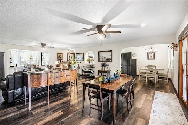 dining room with ceiling fan with notable chandelier, dark hardwood / wood-style flooring, and a textured ceiling