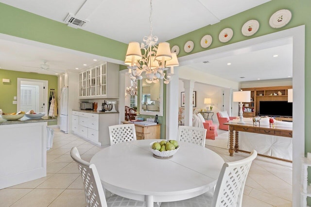 tiled dining room featuring ceiling fan with notable chandelier