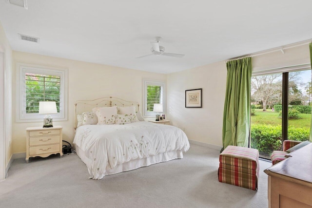 carpeted bedroom with ceiling fan and multiple windows