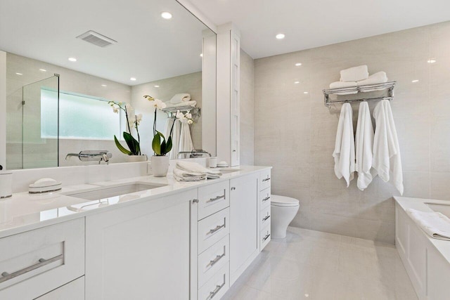 bathroom with tile patterned flooring, vanity, tile walls, and toilet