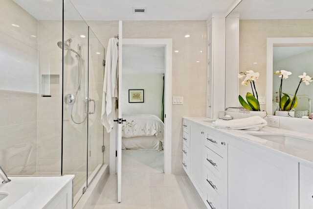 bathroom featuring tile patterned flooring, vanity, and walk in shower