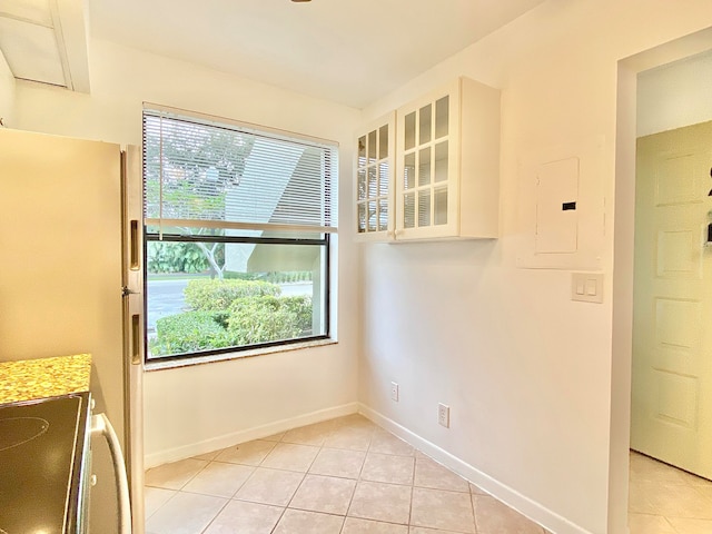 interior space with electric panel and light tile patterned flooring