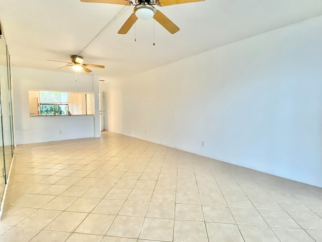 tiled empty room featuring ceiling fan