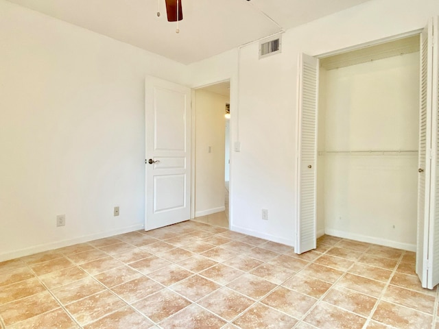 unfurnished bedroom with ceiling fan, light tile patterned floors, and a closet