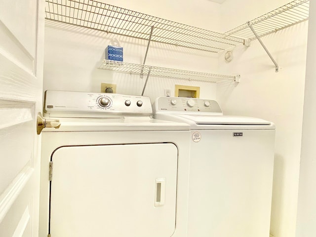 clothes washing area featuring separate washer and dryer