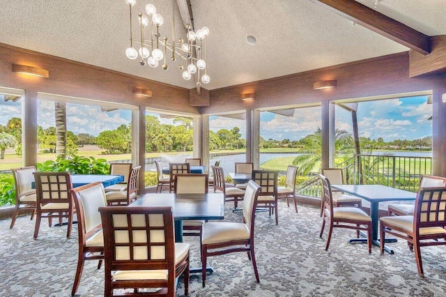 sunroom featuring vaulted ceiling with beams and an inviting chandelier