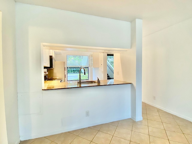 interior space with sink, white cabinetry, stainless steel appliances, and light tile patterned floors