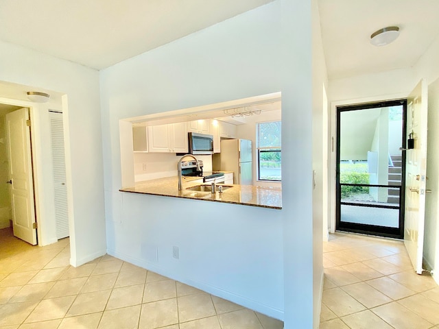 kitchen with white cabinets, sink, stainless steel appliances, and light tile patterned flooring