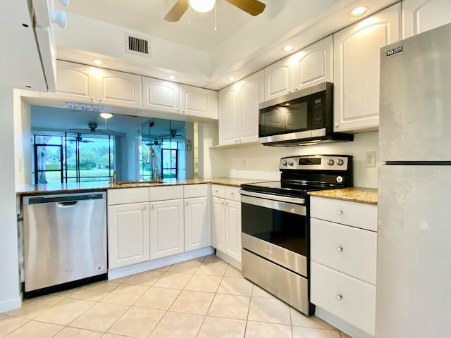 kitchen with white cabinets, ceiling fan, light tile patterned floors, and stainless steel appliances