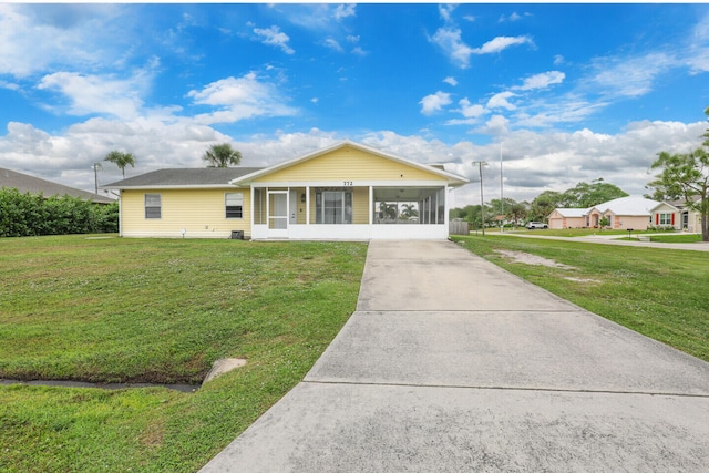 single story home with a sunroom and a front lawn