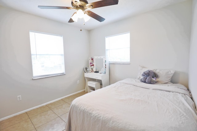 bedroom with multiple windows, light tile patterned floors, and ceiling fan