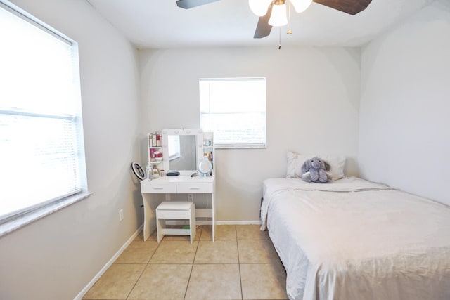 bedroom featuring multiple windows, light tile patterned floors, and ceiling fan