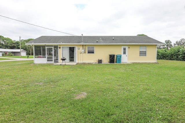 rear view of property featuring a sunroom and a lawn