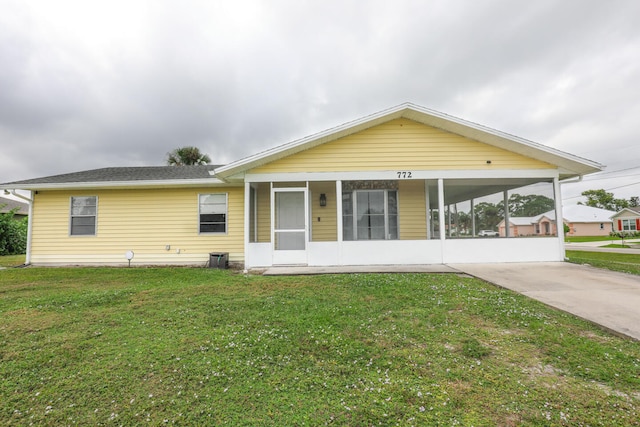 view of front of house with a sunroom and a front lawn