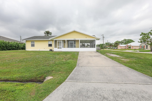 single story home featuring a front yard and a sunroom