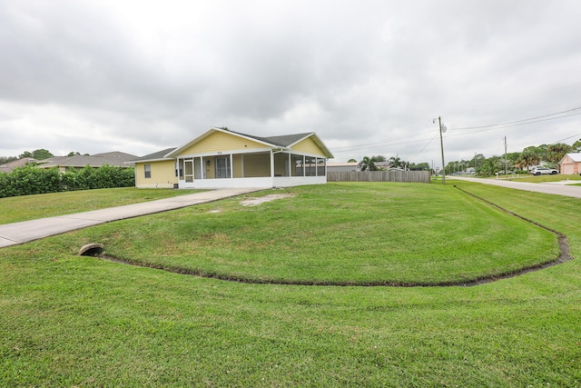 single story home featuring a sunroom and a front lawn