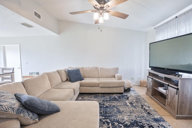 living room featuring ceiling fan, lofted ceiling, and light tile patterned flooring