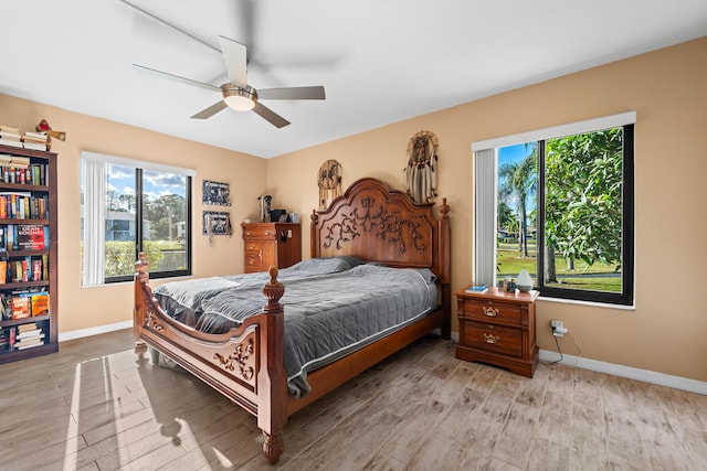 bedroom featuring ceiling fan, light wood-type flooring, and baseboards