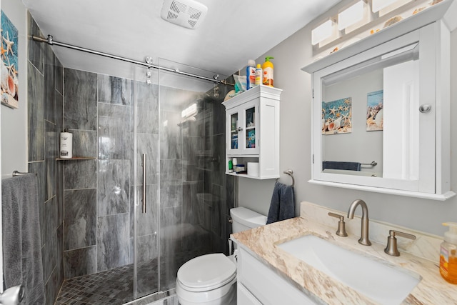 bathroom with visible vents, vanity, toilet, and a shower stall