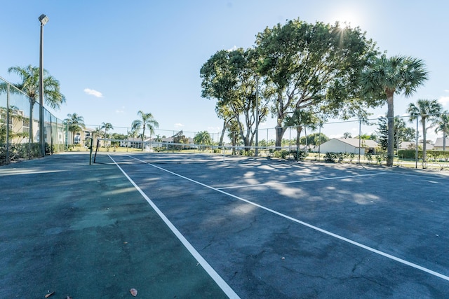 view of sport court with fence and a residential view