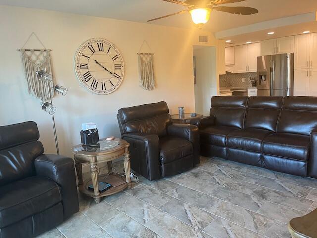 living area with visible vents and ceiling fan