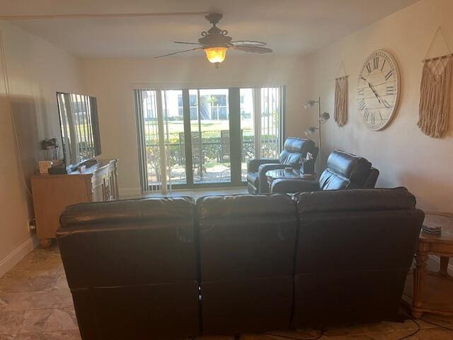 living room featuring baseboards and ceiling fan