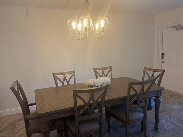 dining room featuring baseboards and a chandelier