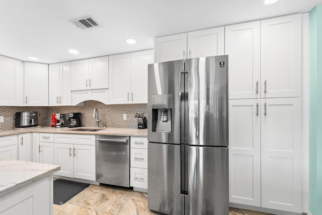 kitchen featuring white cabinets, appliances with stainless steel finishes, and a sink