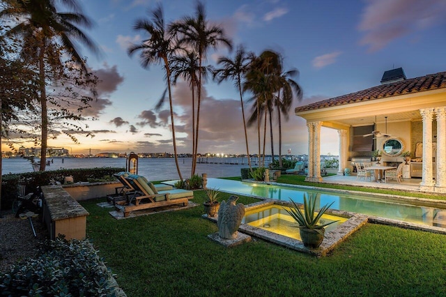 813 N Atlantic Dr, Lantana, FL 33462 - view of pool featuring a yard, a patio area, a water view, a pool with connected hot tub, and a ceiling fan
