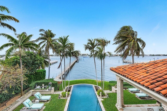 view of swimming pool featuring a yard and a water view