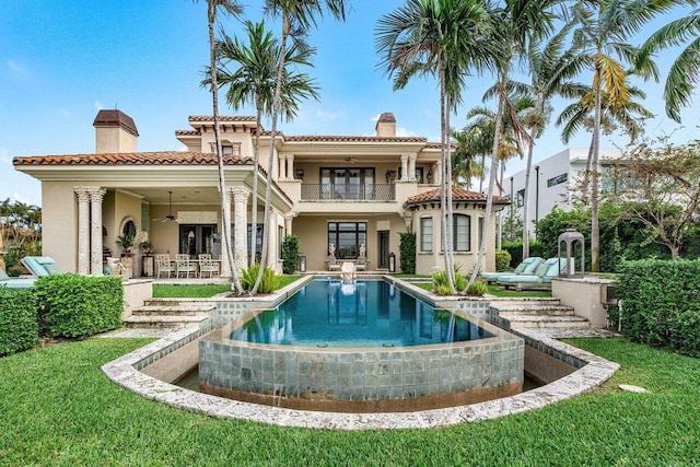 813 N Atlantic Dr, Lantana, FL 33462 - rear view of house with a chimney, a balcony, stucco siding, an infinity pool, and a ceiling fan