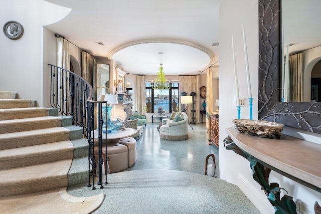 813 N Atlantic Dr, Lantana, FL 33462 - foyer entrance with stairs, arched walkways, speckled floor, and a chandelier