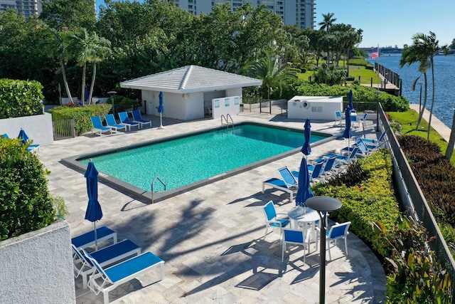 view of pool with a patio and a water view