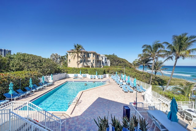 view of swimming pool featuring a water view and a patio area