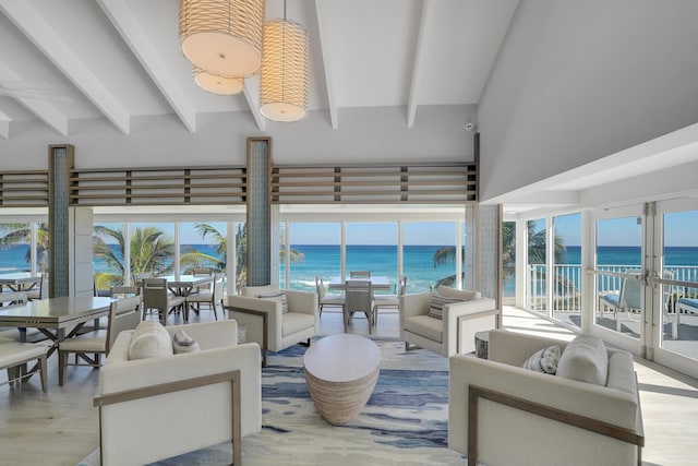 living room with french doors, a water view, beamed ceiling, and light hardwood / wood-style flooring