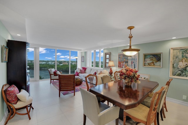 dining room with expansive windows and a water view