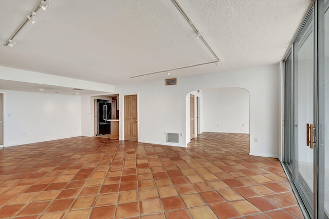 unfurnished room with light tile patterned floors and a textured ceiling