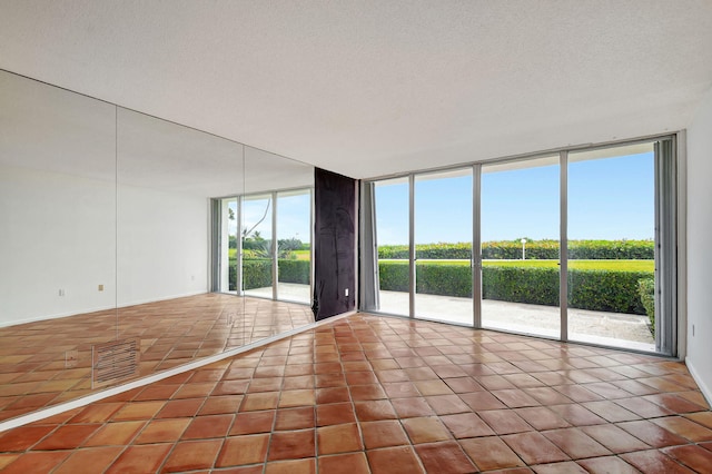 tiled empty room with a textured ceiling