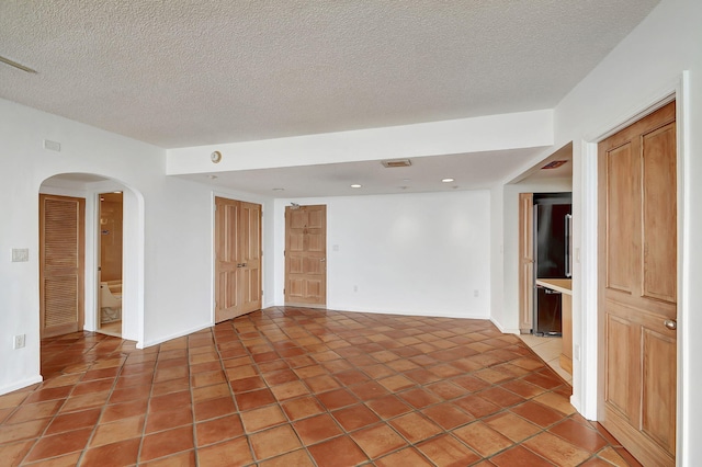 empty room featuring tile patterned floors and a textured ceiling