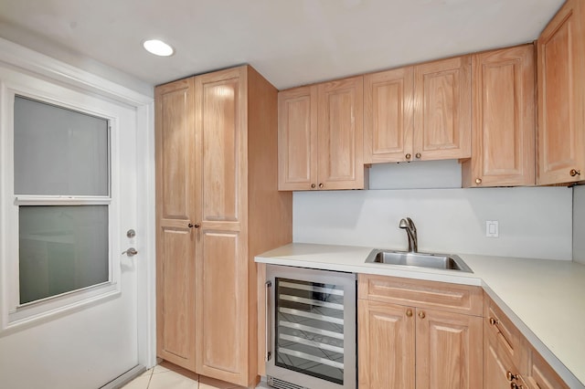 kitchen featuring light brown cabinets, light tile patterned floors, wine cooler, and sink