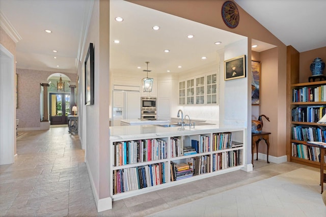 hallway featuring sink, lofted ceiling, and ornamental molding