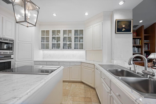 kitchen featuring white cabinets, decorative light fixtures, stainless steel appliances, and sink