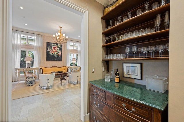 bar with crown molding and a notable chandelier