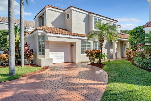 mediterranean / spanish-style house with a garage and a front lawn