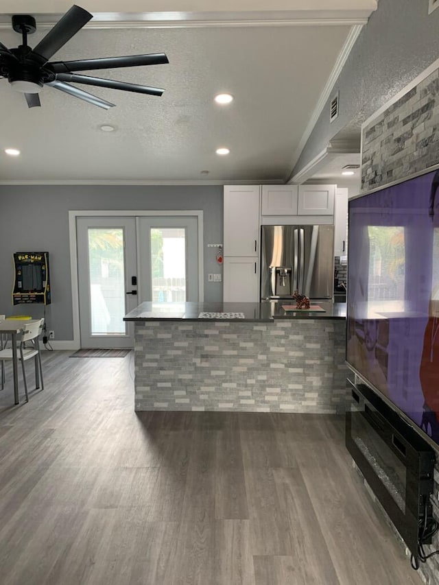 kitchen with french doors, ornamental molding, wood-type flooring, white cabinets, and stainless steel fridge with ice dispenser