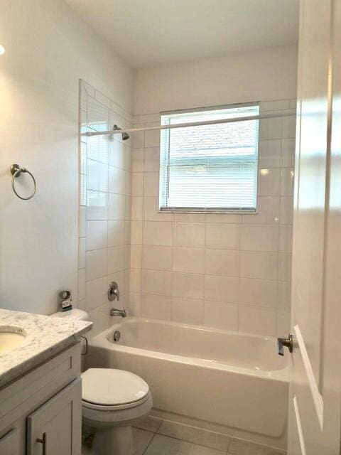 full bathroom featuring tile patterned flooring, vanity, toilet, and tiled shower / bath