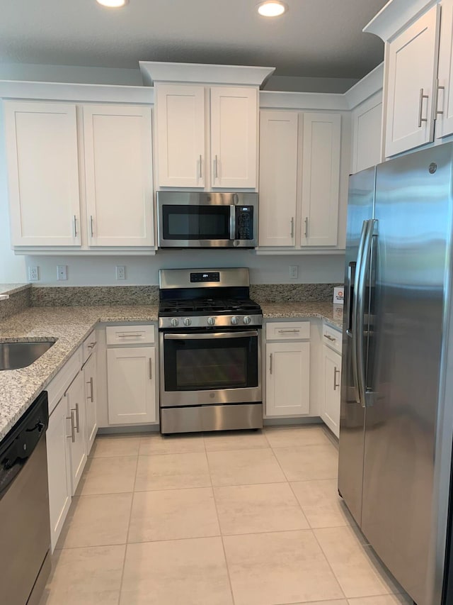 kitchen featuring light stone countertops, sink, white cabinets, and stainless steel appliances