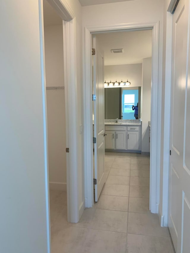 corridor with sink and light tile patterned floors